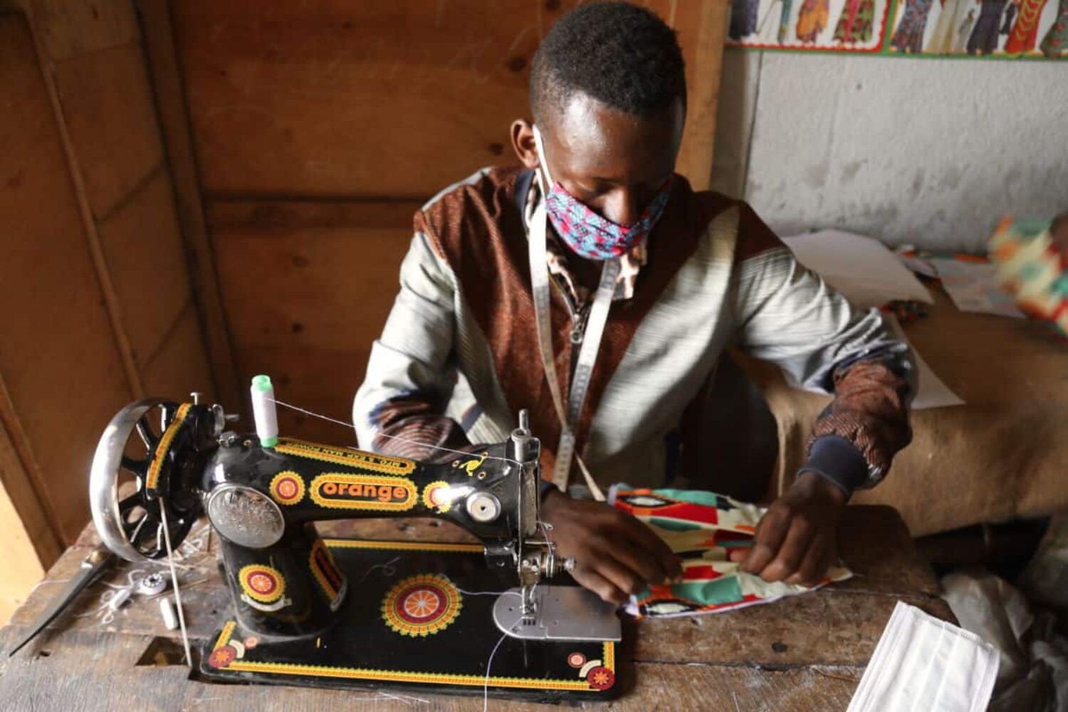 A tailor in Goma making a colourful face mask to help halt the spread of coronavirus