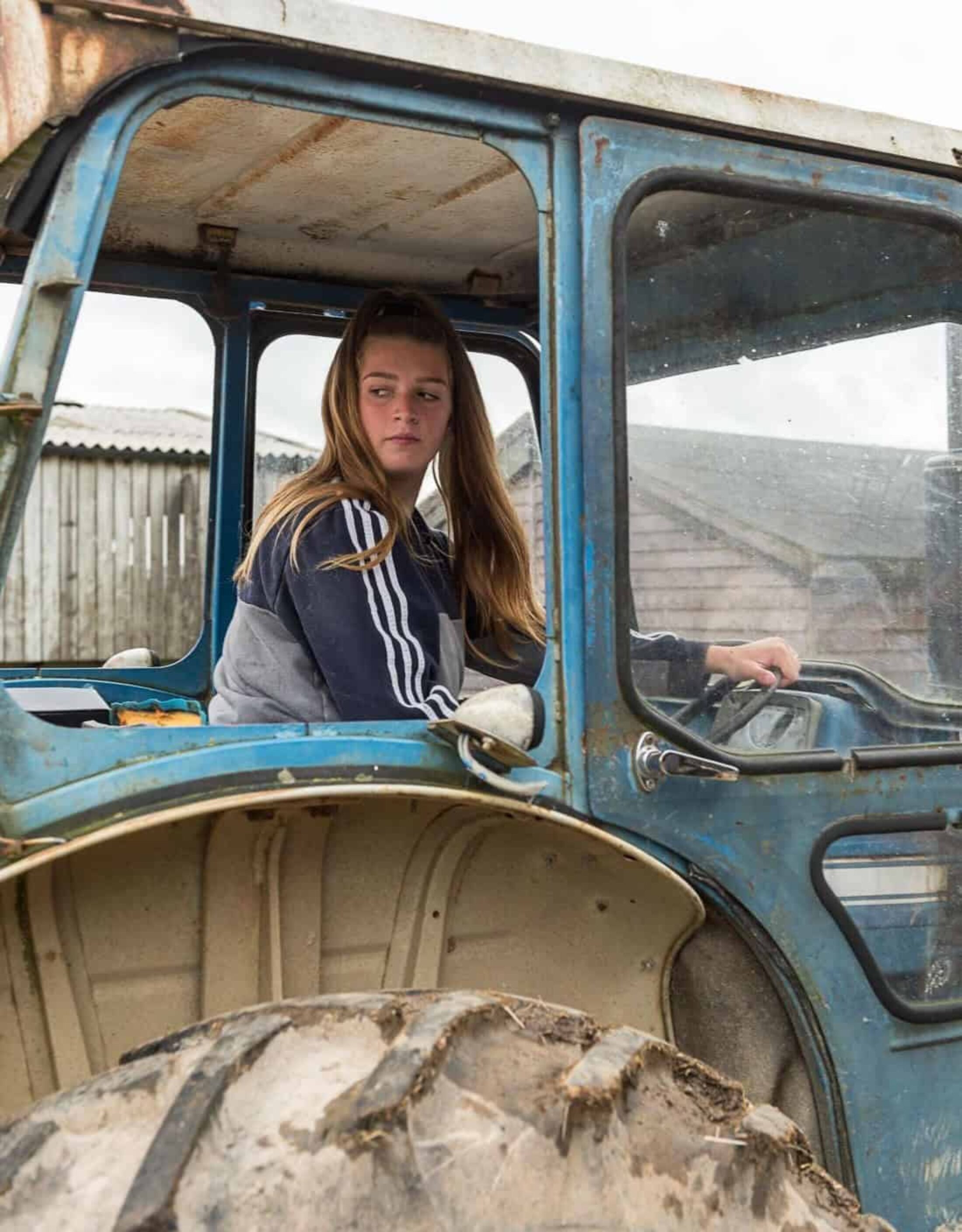 A young person learns to drive a tractor at Rylands Farm in Dorset